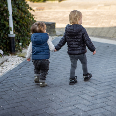twee kinderen lopen hand in hand