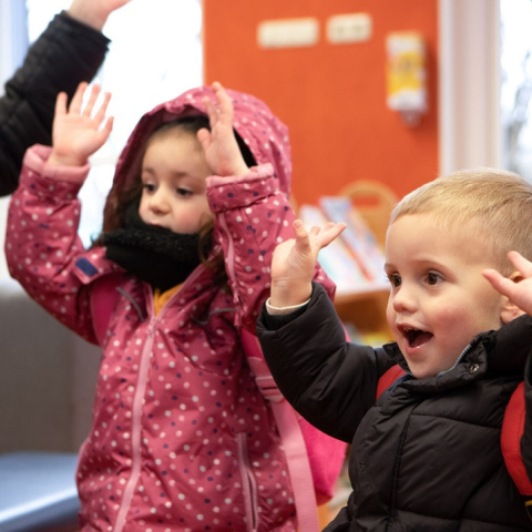 kinderen doen handen in lucht