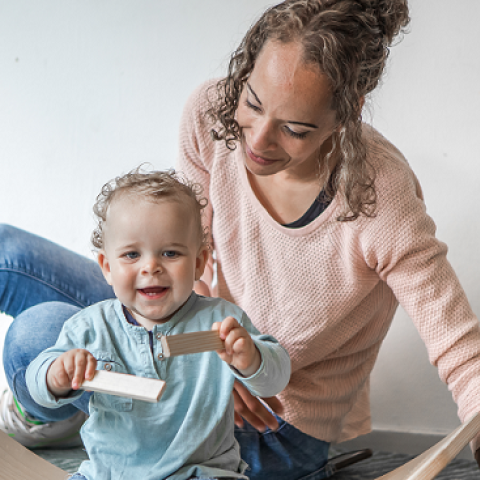 Pedagogisch professional met kind op grond