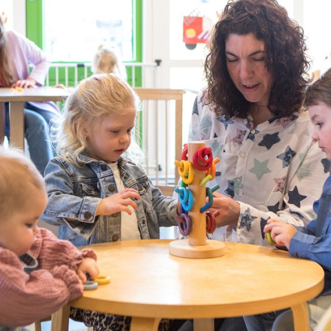 pedagogisch professional met kinderen aan tafel