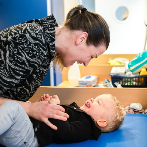 pedagogisch medewerker speelt met kind