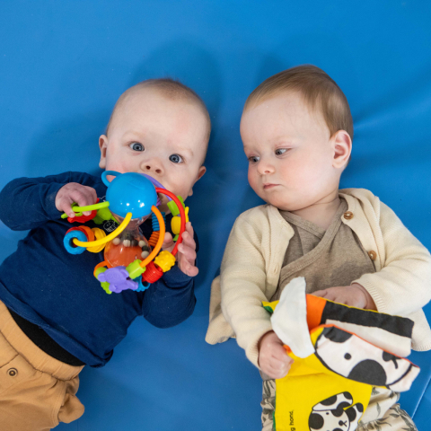 twee baby's spelen samen op de grond
