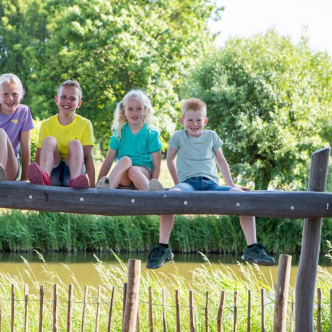 BSO kinderen zitten op een balk